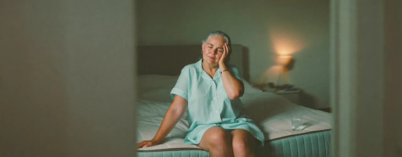 Woman sitting on edge of bed with dizziness from BPPV vertigo - treated at Synergy Therapeutic Group, Carbondale IL