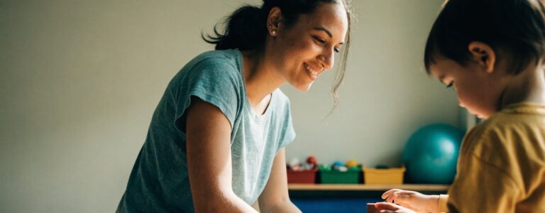 Pediatric occupational therapist observing a young child stacking blocks during an evaluation in Carbondale, IL